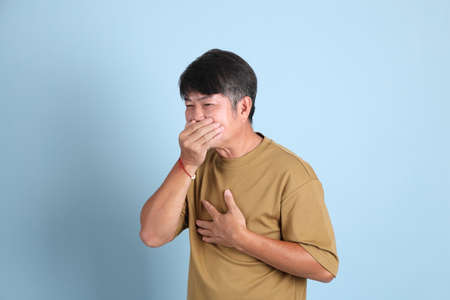 The senior Asian man with casual clothes standing on the blue background.の写真素材