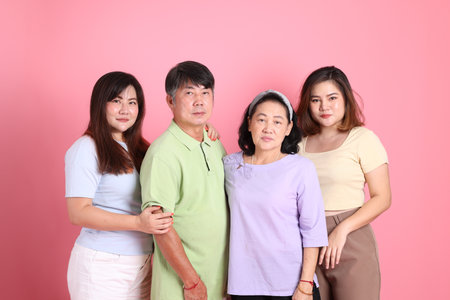 The happy Asian family standing on the pink background.の写真素材
