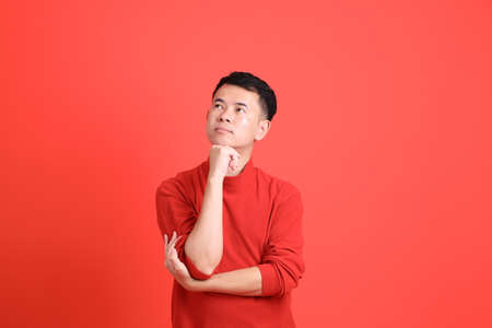 The Asian LGBTQ man with red shirt standing on the orange background.の写真素材