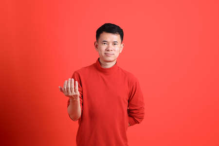 The Asian LGBTQ man with red shirt standing on the orange background.の写真素材