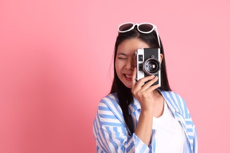 The Asian adult woman with casual clothes standing on the pink background.の写真素材