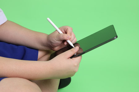 The Asian boy with student uniform on the green background.の写真素材