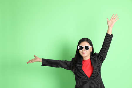 The Asian businesswoman standing on the pastel green background.の写真素材
