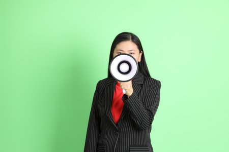 The Asian businesswoman standing on the pastel green background.の写真素材