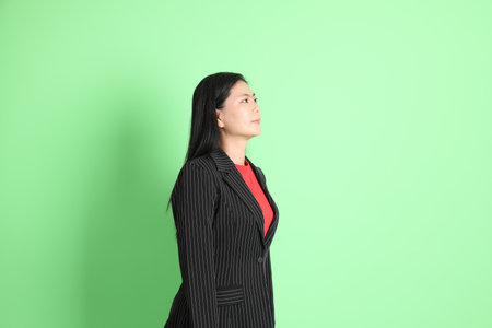 The Asian businesswoman standing on the pastel green background.の写真素材
