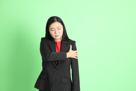 The Asian businesswoman standing on the pastel green background.の写真素材