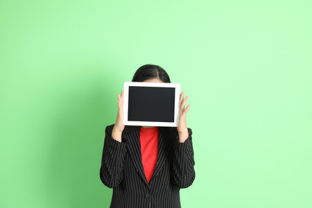 The Asian businesswoman standing on the pastel green background.の写真素材