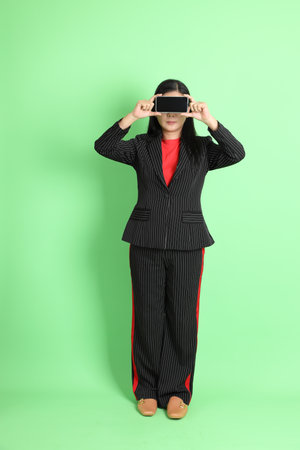 The Asian businesswoman standing on the pastel green background.の写真素材