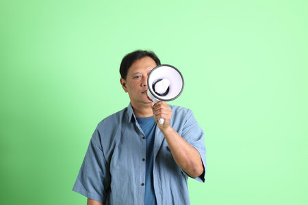 The 40s adult overweight Asian man standing on the green background.の写真素材