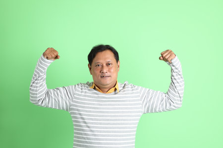 The 40s adult overweight Asian man standing on the green background.の写真素材