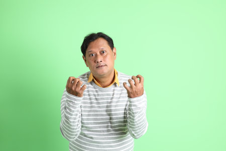 The 40s adult overweight Asian man standing on the green background.の写真素材