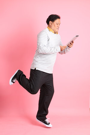 The 40s adult overweight Asian man standing on the pink background.の写真素材