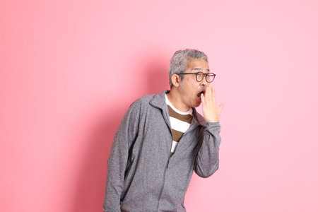 The 40s adult Asian man stnading on the pink background with casual clothes.の写真素材