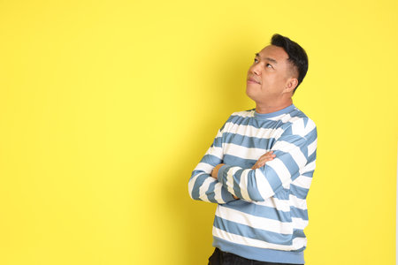 The 40s adult Asian man with standing on the yellow background.