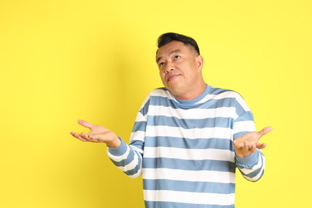 The 40s adult Asian man with standing on the yellow background.の写真素材