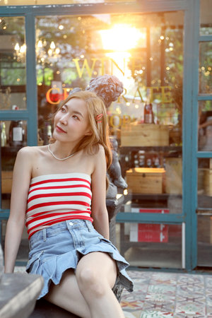 The cute Asian woman feeling relax posing in the outdoor restaurant.の写真素材
