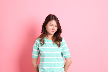 The young adult Asian woman with casual clothes on the pink background.の写真素材