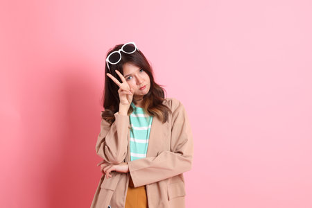 The young adult Asian woman with casual clothes on the pink background.の写真素材