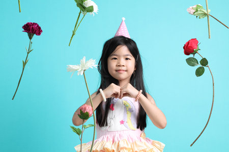 The little Asian girl with floating flower on the green background.の写真素材