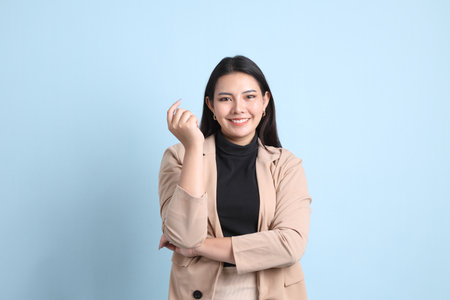 The Asian businesswoman standing on the blue background.の写真素材