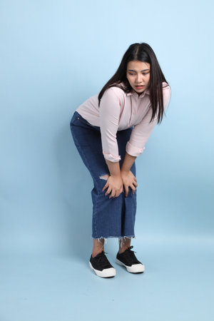 The Asian woman in casual clothes standing on the blue background.の写真素材