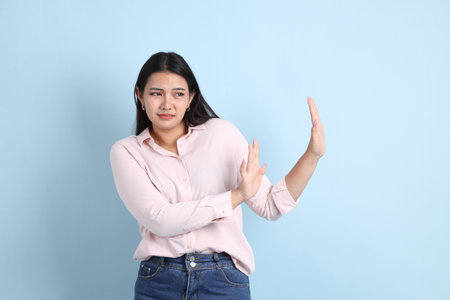 The Asian woman in casual clothes standing on the blue background.の写真素材