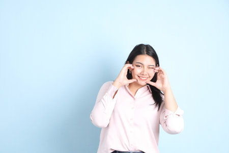 The Asian woman in casual clothes standing on the blue background.の写真素材