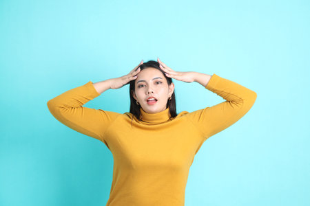 The Asian woman in casual clothes standing on the green background.の写真素材