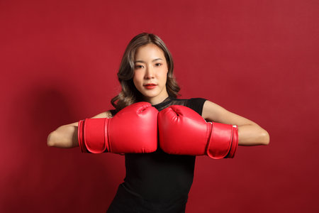 The Asian woman with black color dressed standing on the red background.の写真素材