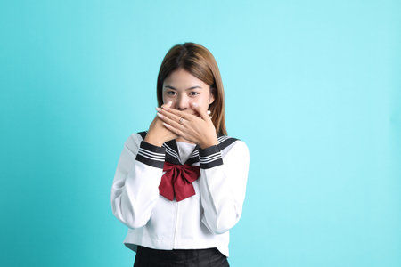 The Asian girl in Japanese student uniform standing on the green background.の写真素材