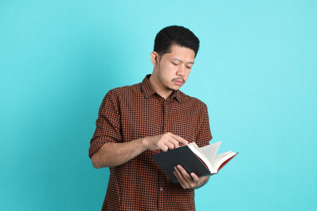 The adult Asian man in smart casual clothes standing on the green background background.の写真素材