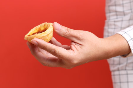 The Asian man hand holding egg tart in the orange background.の写真素材