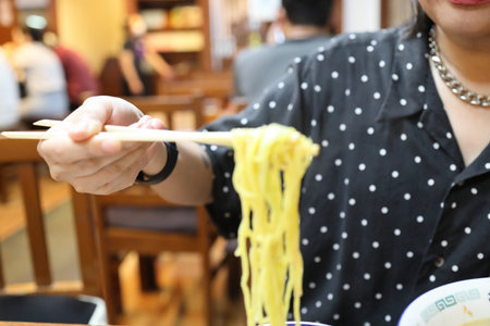 The Asian woman eating ramen in the restaurant.の写真素材