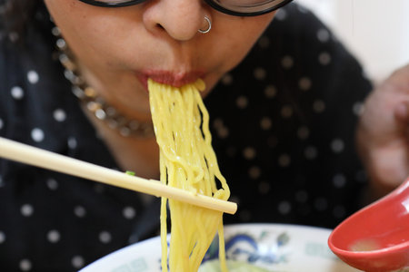 The Asian woman eating ramen in the restaurant.の写真素材