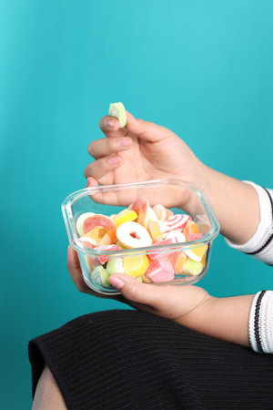 The Asian woman holding jelly in the hand on the green background.の写真素材