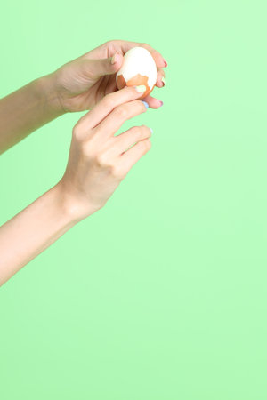 The Asian woman holding egg in the hand on the green background.の写真素材