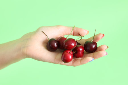 The Asian woman holding berry fruit in the hand on the yellow background.の写真素材