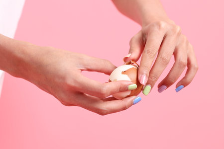 The Asian woman eating egg in the hand on the green background.の写真素材