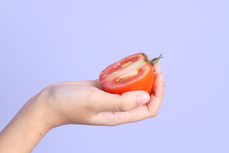 The Asian woman hand holding pomelo in the purple background.の写真素材