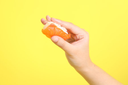 The Asian woman hand holding sushi in the purple background.の写真素材