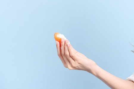 The Asian woman hand holding sushi in the blue background.の写真素材