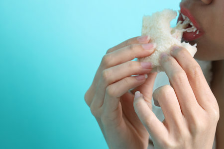 The Asian woman eating sandwiches on blue background.の写真素材