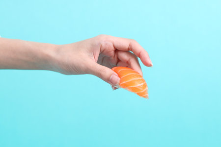 The Asian woman holding sushi on green background.の写真素材
