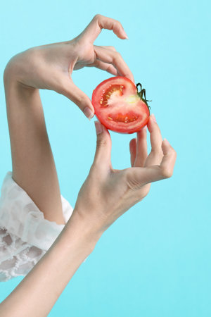 The Asian woman hand holding tomato in the green background.の写真素材