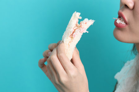 The Asian woman eating sandwiches on blue background.の写真素材