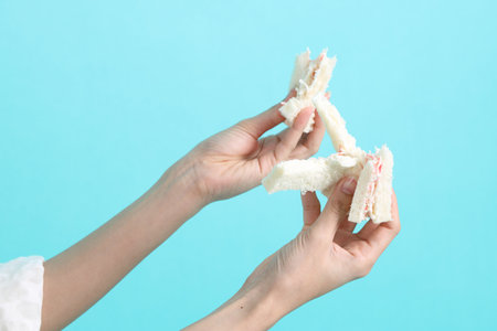 The Asian woman eating sandwiches on blue background.の写真素材