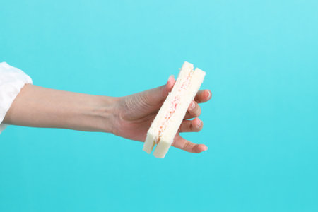 The Asian woman eating sandwiches on blue background.の写真素材