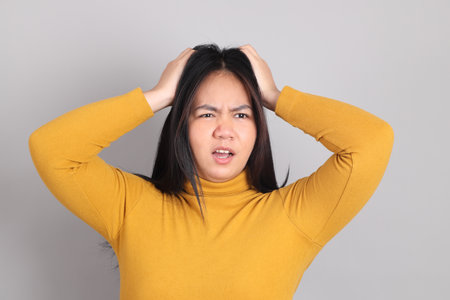 The adult Southeast Asian woman standing on the grey background.の写真素材