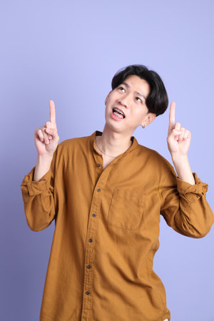 The Adult east Asian man with braces standing on the blue background.の写真素材