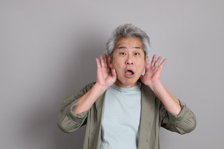 The 40s Asian man with smart casual clothes standing on the grey background.の写真素材
